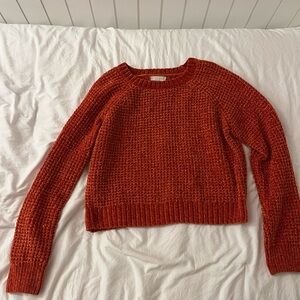 A large cropped orange sweater from Altar’d State